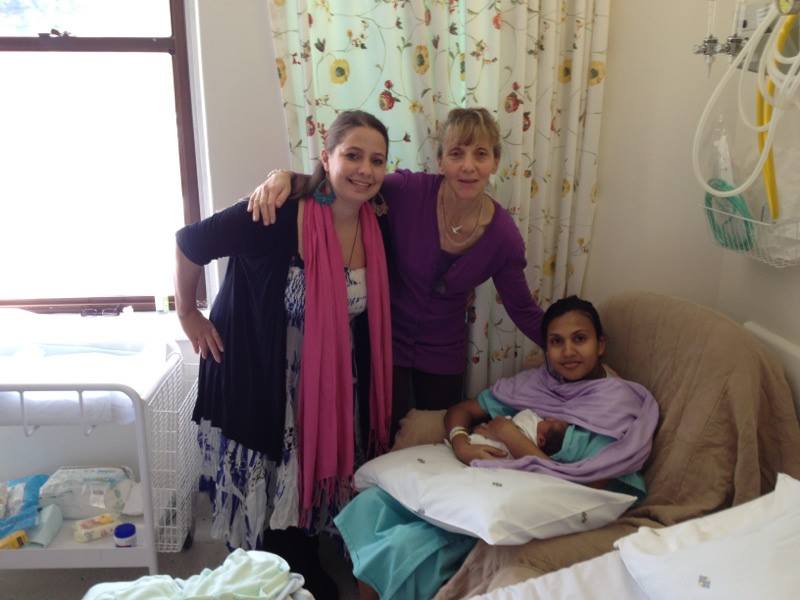 Two WOMBS doulas with a new mother holding her newborn in hospital